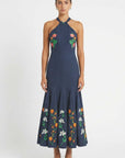 Front view ofErva Dress showcasing  embroidered halter-neck dress with floral embroidery framing the bodice and hem.