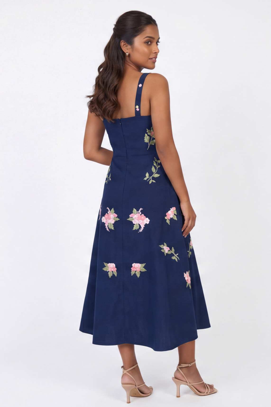 Model wearing the Fanm Mon Fisayo Dress featuring floral vine embroidery, square back neckline, fitted bodice, and midi-length silhouette in back view against a neutral studio background.