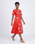 Model wearing the Fanm Mon Hannah Dress with hand-placed tulip and floral embroidery, round neckline, short sleeves, and elegant midi silhouette in front view against an off-white background.