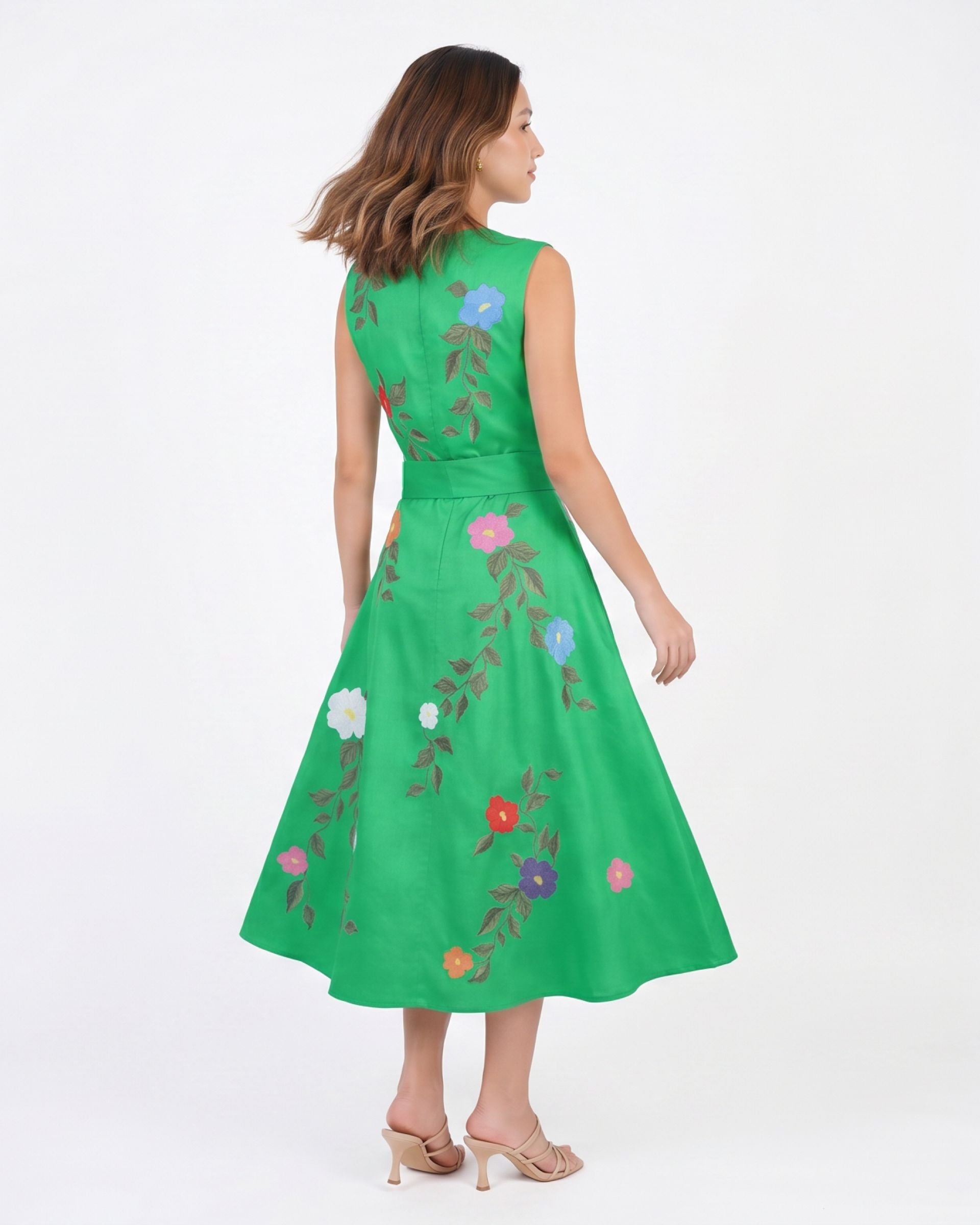Model wearing the Fanm Mon Jules Dress featuring hand-placed floral vine embroidery, sleeveless bodice, self-tie waist belt, and flowing midi skirt in back view against a neutral background.
