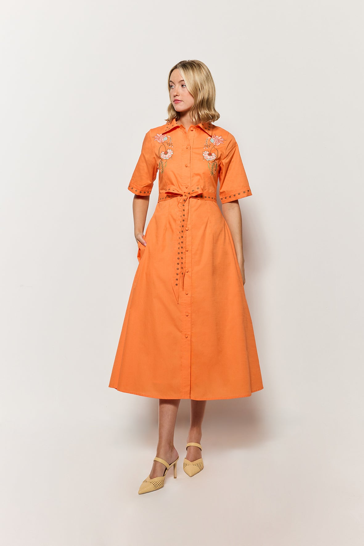 Model Wearing Kenya Midi Length Button Front Shirt Dress in Orange with floral embroidery details