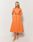 Model Wearing Kenya Midi Length Button Front Shirt Dress in Orange with floral embroidery details