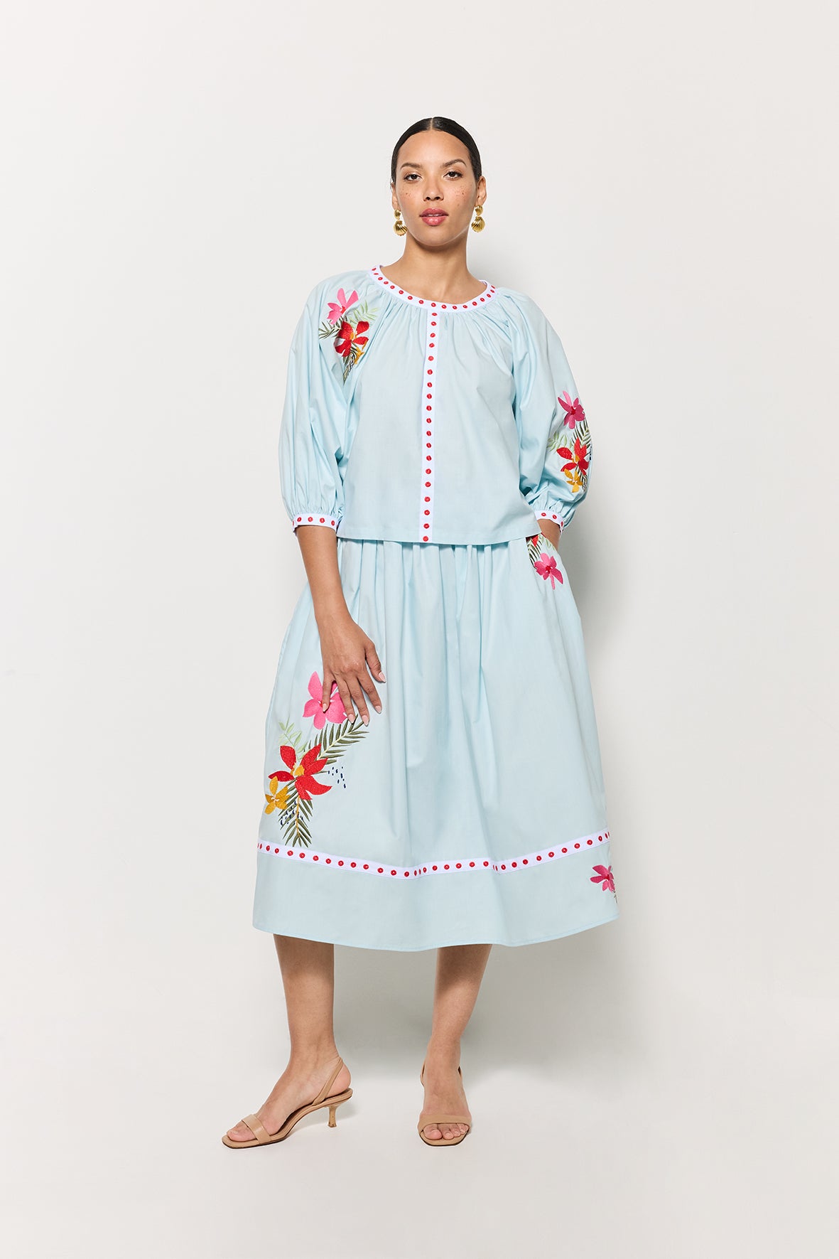 Model styled in the Kronso Blouse and Skirt Set, adorned with delicate floral embroidery on both pieces, set against a clean white backdrop.