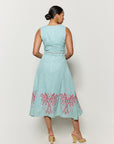 Backview of model wearing Fanm Mon's Libya Midi Dress in Green Check plaid with pink floral embroidery on a white background