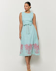 Model wearing Fanm Mon's Libya Midi Dress in Green Check plaid with pink floral embroidery on a white background