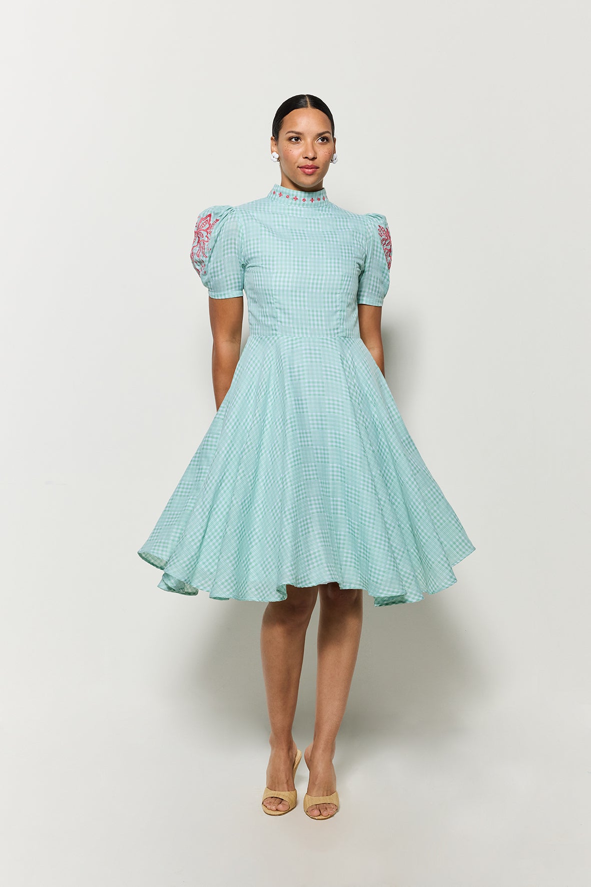 Model in Fanm Mon Lipno Dress front view showcase movement of full skirt, short puff sleeves and high neckline. 