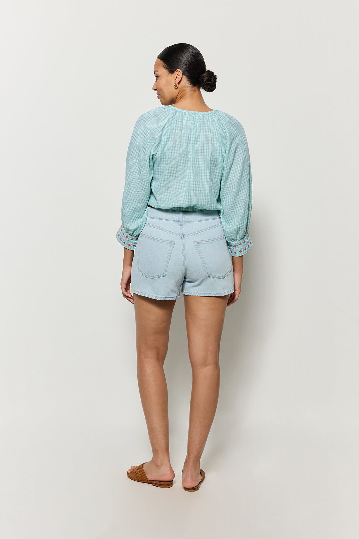 Backview of Model wearing Fanm Mon’s Motanka, slightly cropped top in green checker plaid.