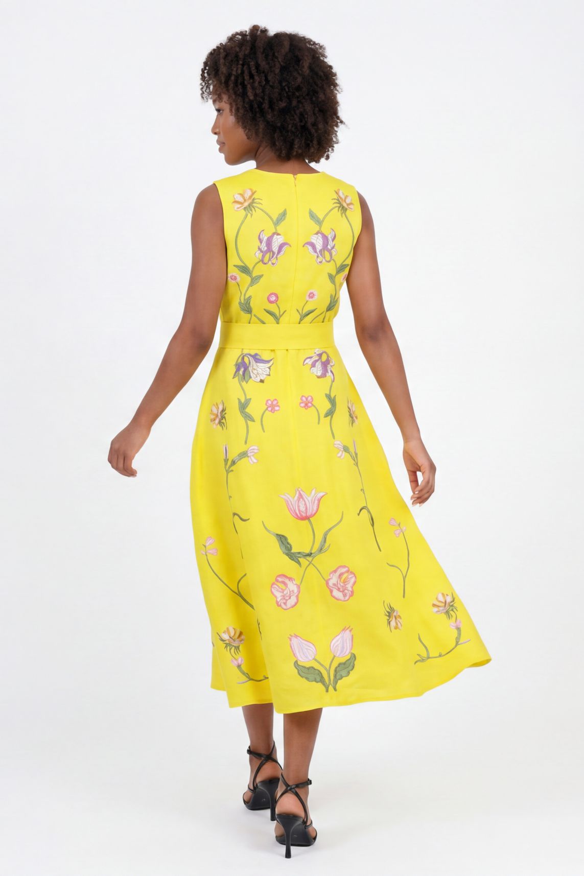 Back View of the Nosa Dress showcasing movement of the dress and featuring floral embroidery details inspired by tulips