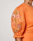 Detail shot of the blooming  floral embroidery that can be found  on Fanm Mon's Pintada Dress on both the sleeves and hemline.