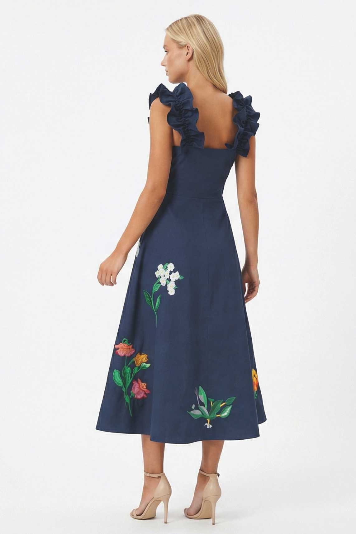 Back view of embroidered midi dress with ruffled straps and floral embroidery extending across the skirt.