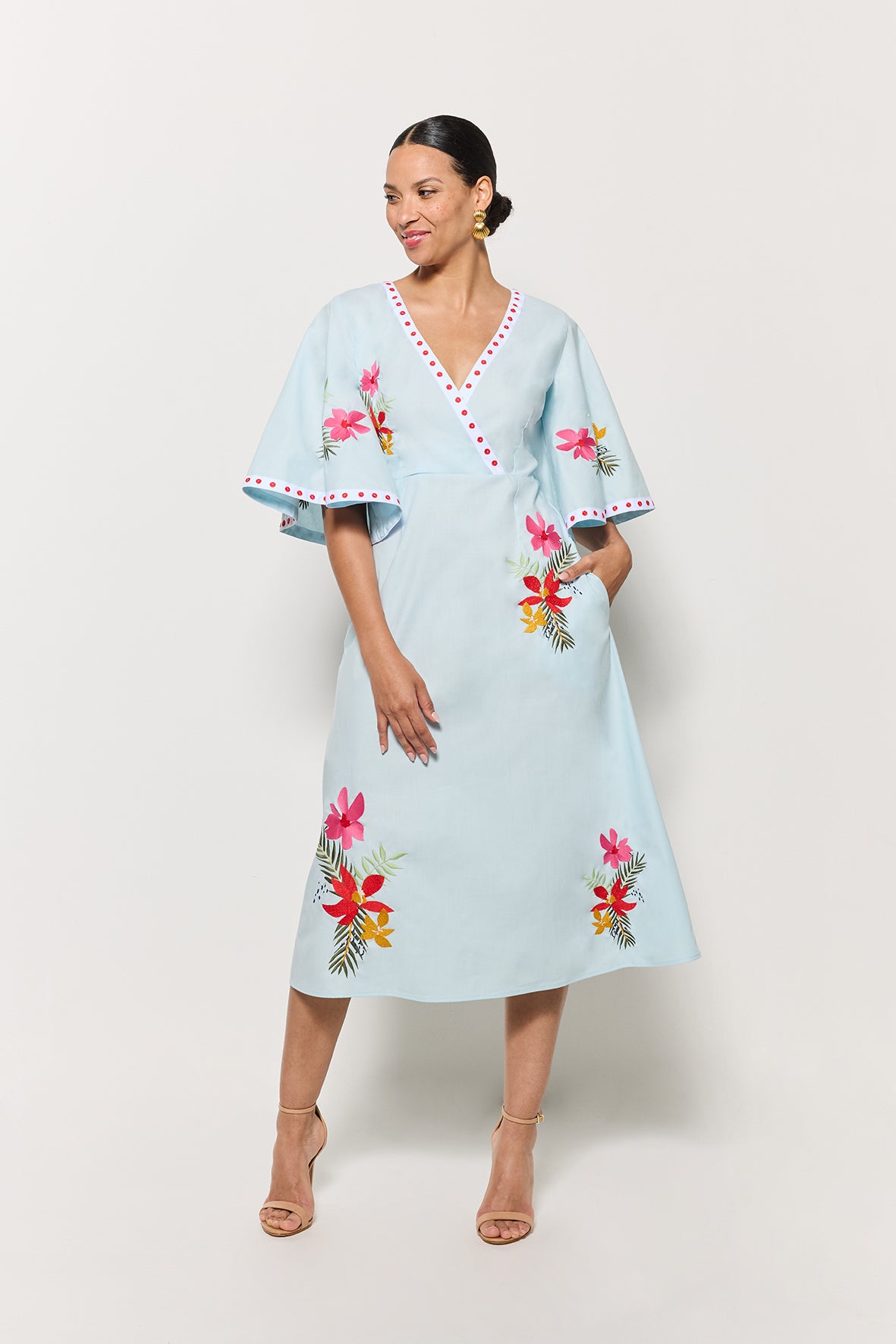 Model in Fanm Mon Tinto Dress in light lagoon with floral embroidery on a white background