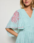 Detail shot of  Fanm Mon's Tunus Midi Dress in Green Check plaid with pink floral embroidery showcasing sleeve detail.  