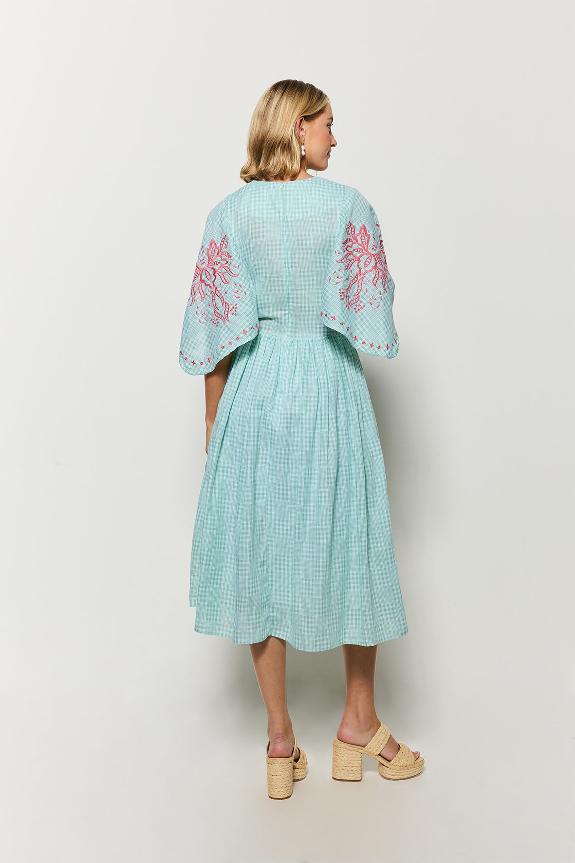 Backview of Fanm Mon's Tunus Midi Dress in Green Check plaid with pink floral embroidery, showcasing the full bat like sleeves