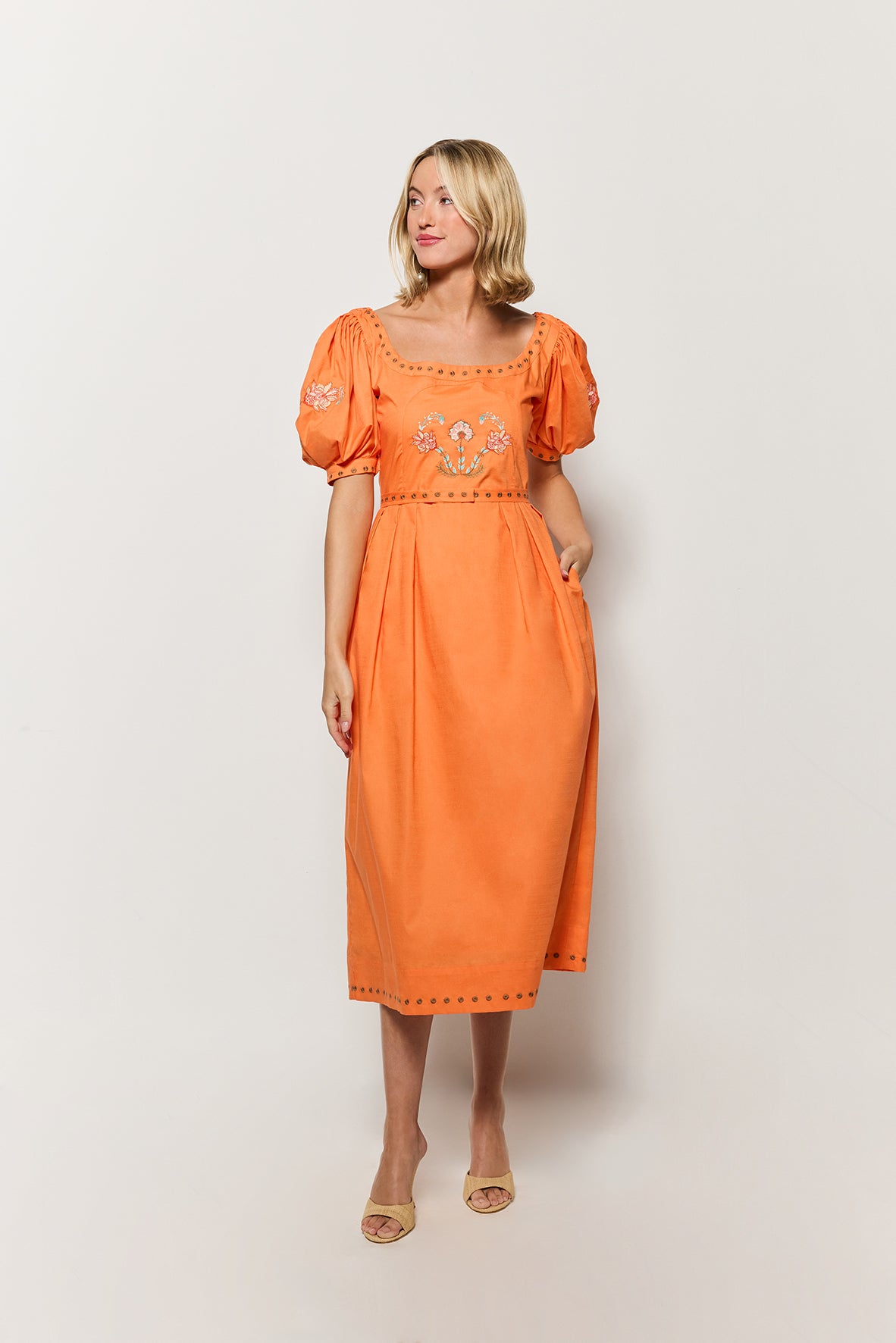 Model in Fanm Mon's Braga Dress, showcasing square neckline, puff sleeves, and embroidery details. Front view of the model on white background. 
