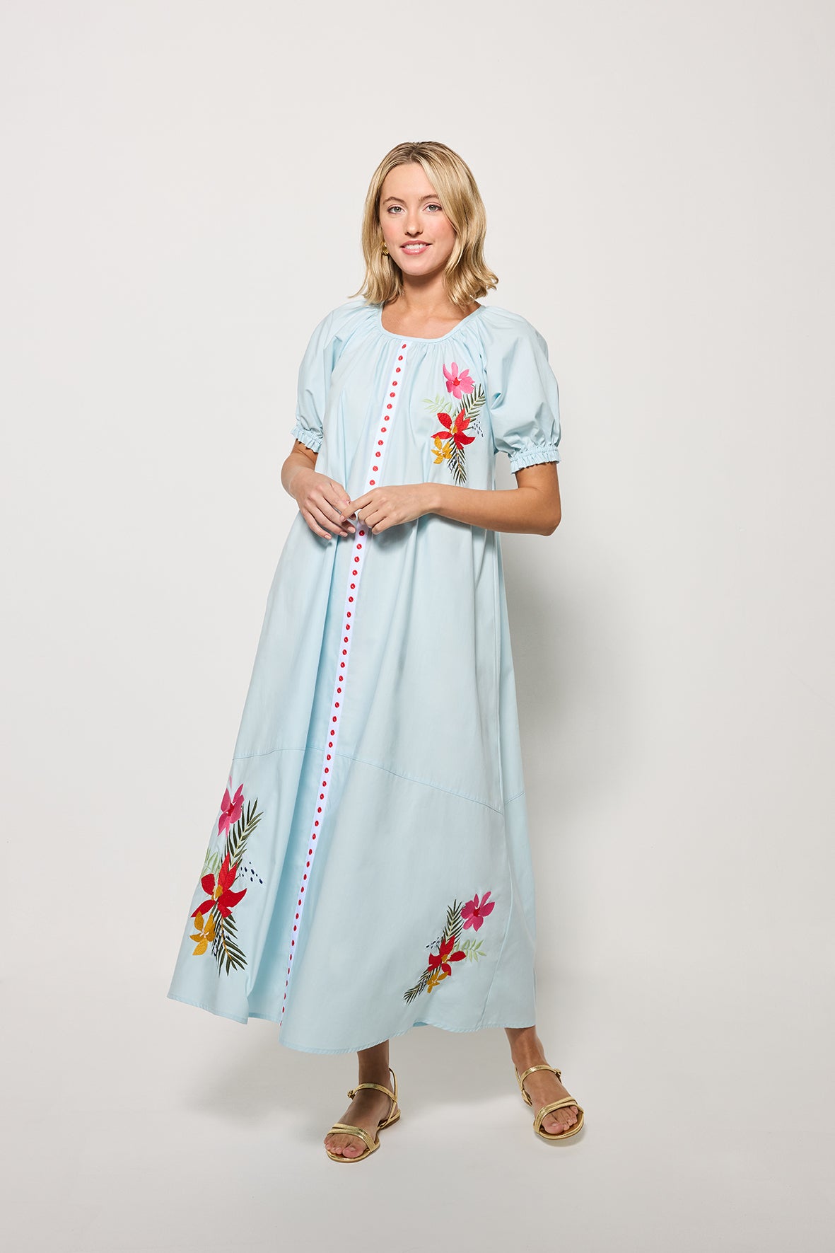 Model showcasing the movement of the Evora Midi Length dress in Light Lagoon with  floral embroidery on a white background