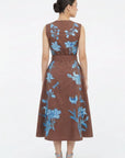Back view of the Fanm Mon Gera Dress featuring blue botanical and floral embroidery, delicate insect motifs, a defined waist, and full midi skirt.