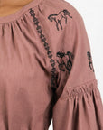 Close-up of the Fanm Mon Hayal Dress highlighting horse embroidery, contrast embroidered detailing, and gathered sleeve.