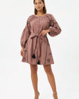 Model wearing the Fanm Mon Hayal Dress featuring a button-front closure, horse embroidery, voluminous sleeves, tassel accents, and a self-tie waist belt. Perfect for Horse lovers.