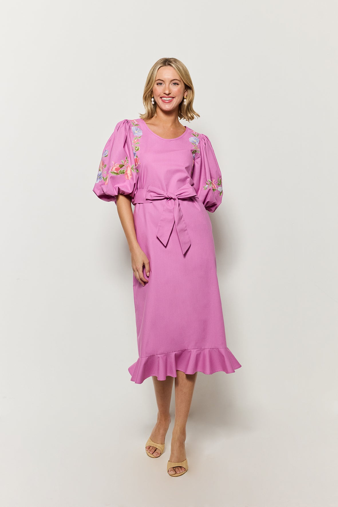 Woman wearing a deep plum cotton short-sleeve fanm mon dress with floral embroidery.