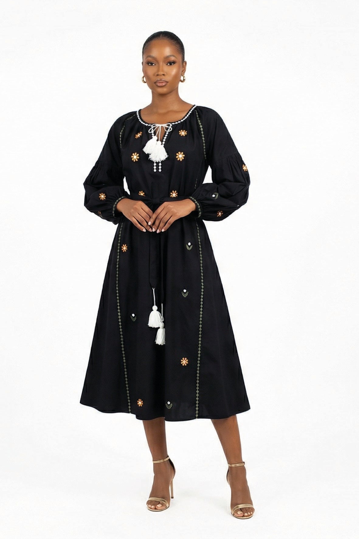 Model wearing the Fanm Mon Lavina Dress featuring floral embroidery, voluminous sleeves, a self-tie waist belt, and tassel neckline.