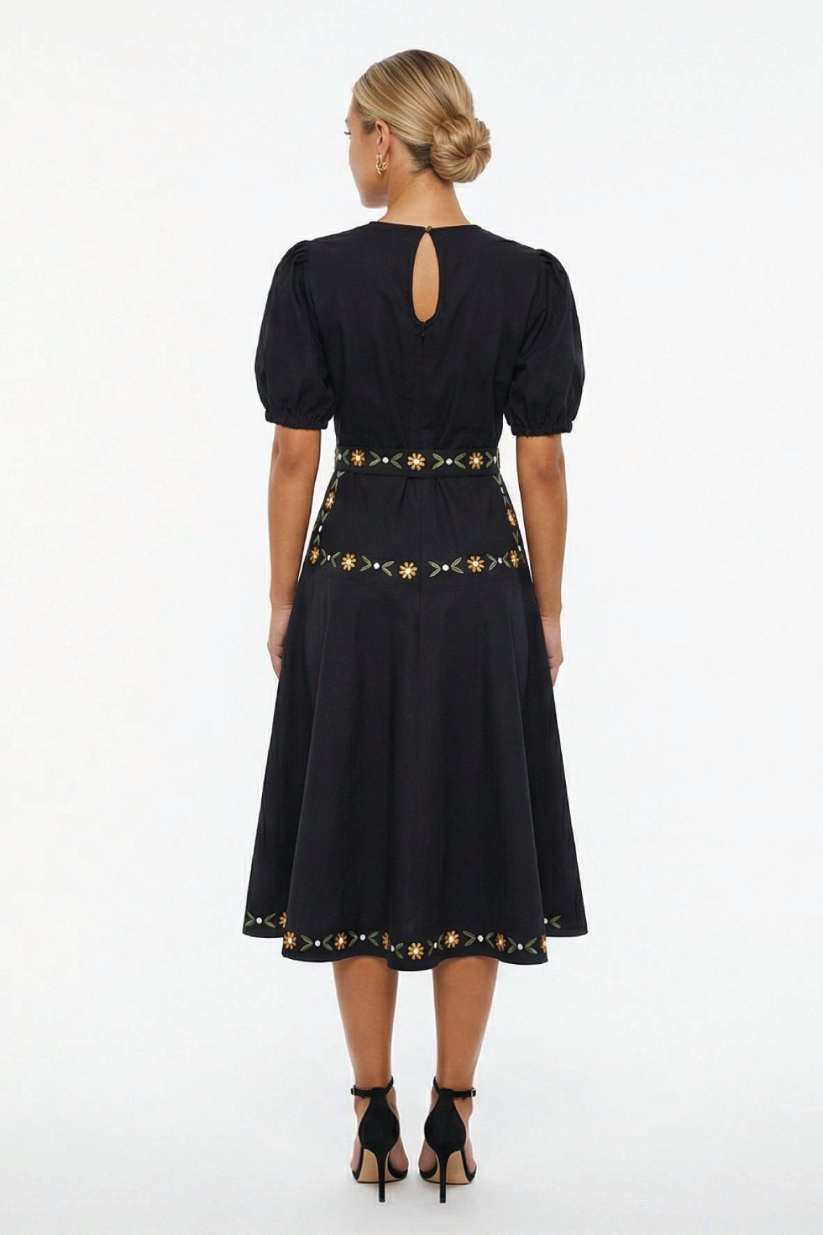 Back view of the Fanm Mon Lesley Dress showcasing the concealed back zipper with keyhole closure, fitted waist, embroidered daisy vine detailing, and flowing A-line midi skirt.