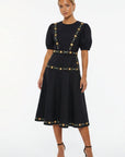 Model wearing the Fanm Mon Lesley Dress featuring a crew neckline, puff short sleeves, hand-embroidered daisy vines, fitted bodice, defined waist, and an A-line midi skirt.