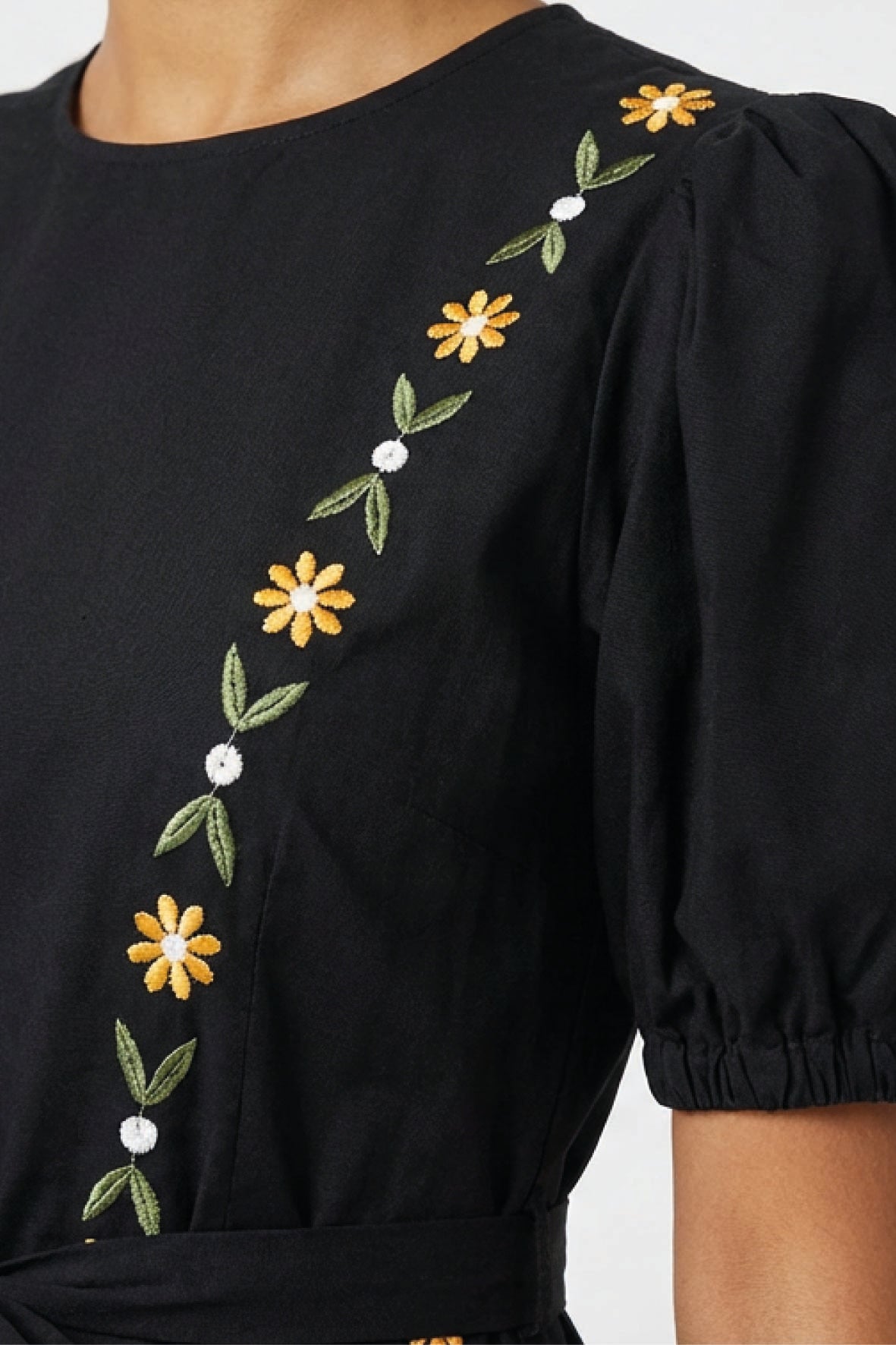 Close-up of the Fanm Mon Lesley Dress highlighting the hand-embroidered daisy vine motif, puff sleeve detailing, and artisan floral embroidery across the bodice.