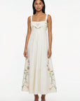 Striaght on view of Model wearing the Fanm Mon Leyla Dress featuring tulip, cosmos, buttercup, and lily embroidery, a square neckline,  and embroidered straps.