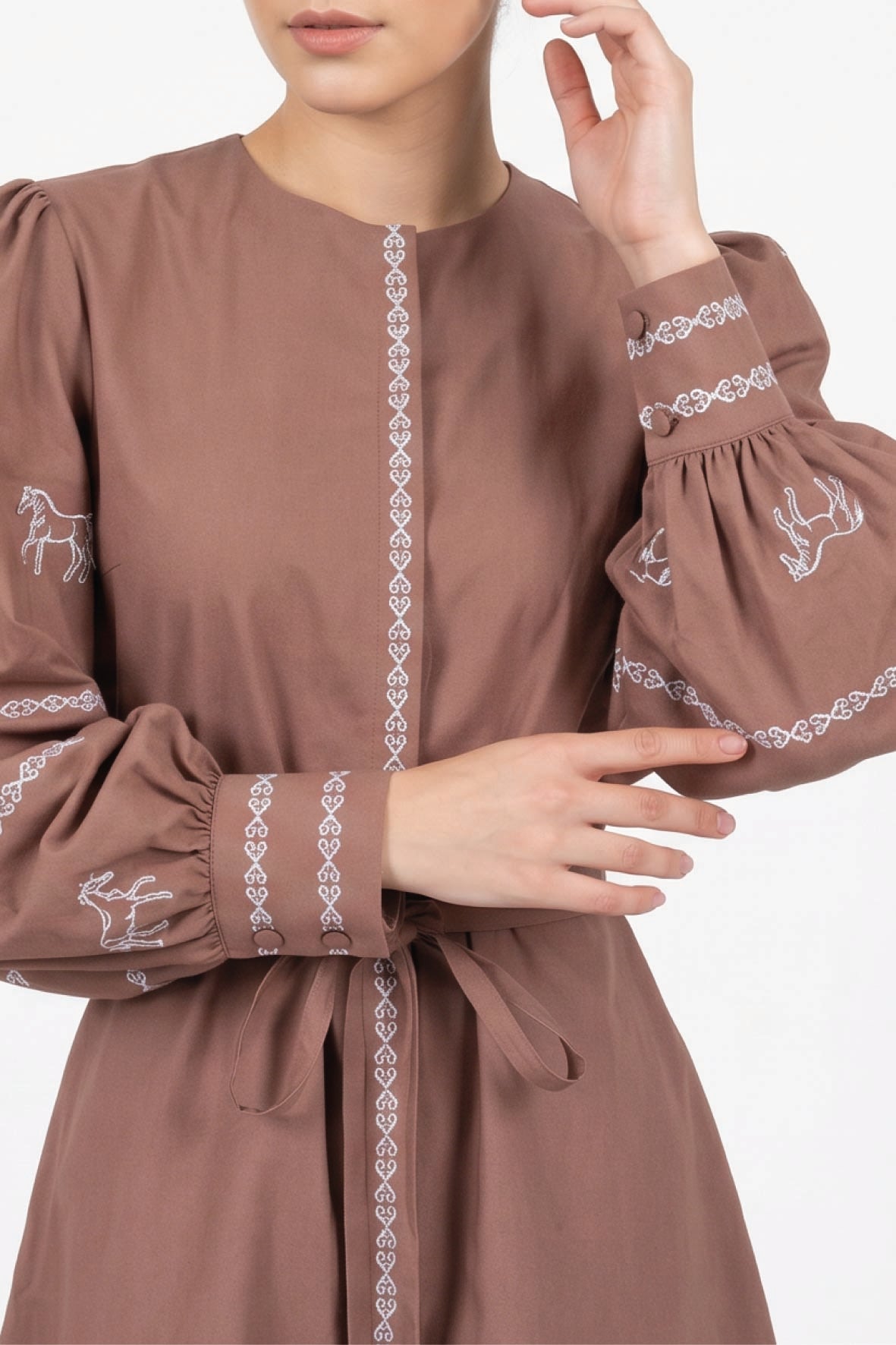 Fanm Mon Mel Dress detail featuring embroidered horse motifs, decorative embroidered trim and button cuffs.