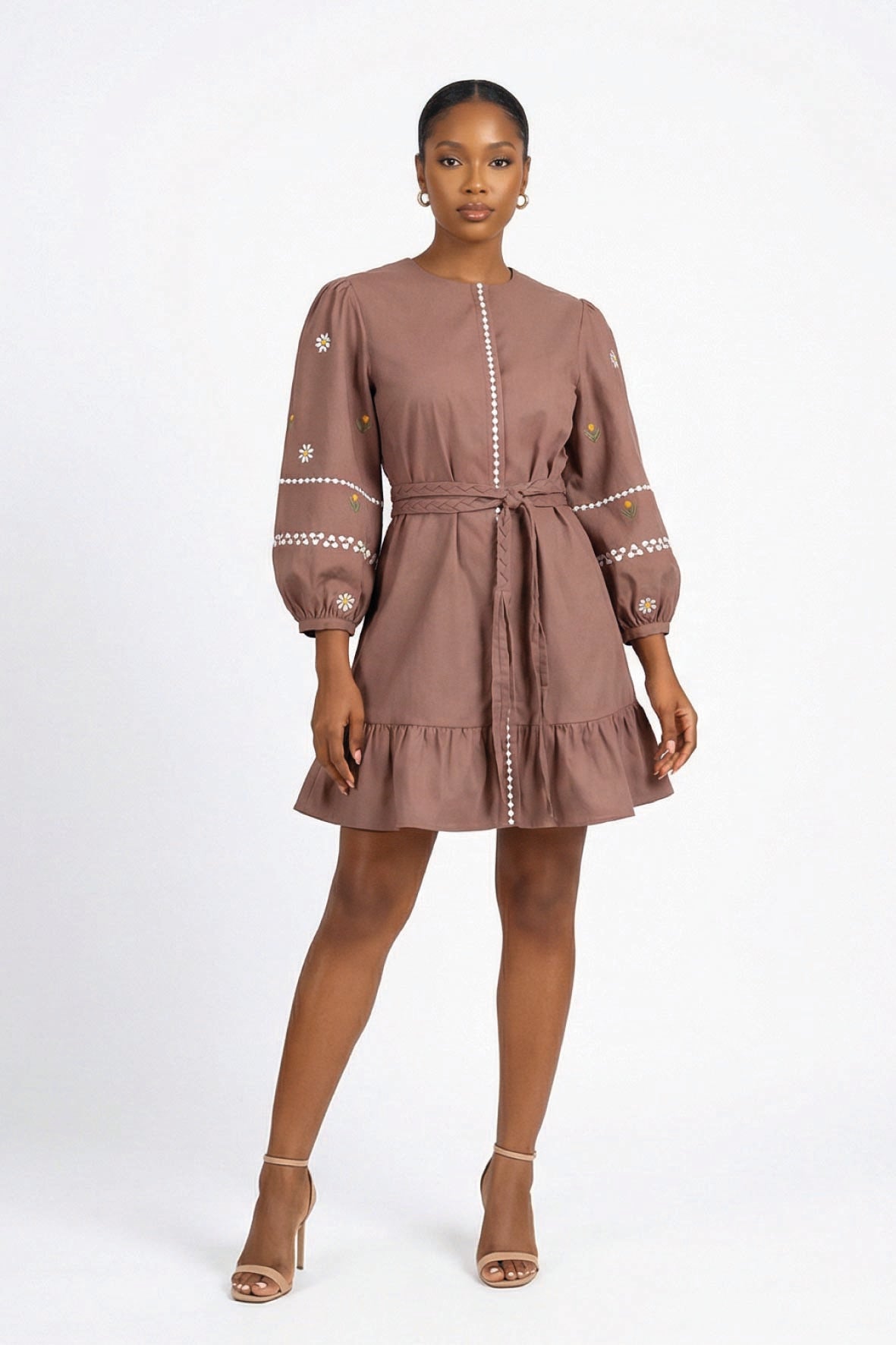 Fanm Mon Noen Dress on model featuring daisy floral embroidery, long blouson sleeves, braided tie waist and ruffled hem
