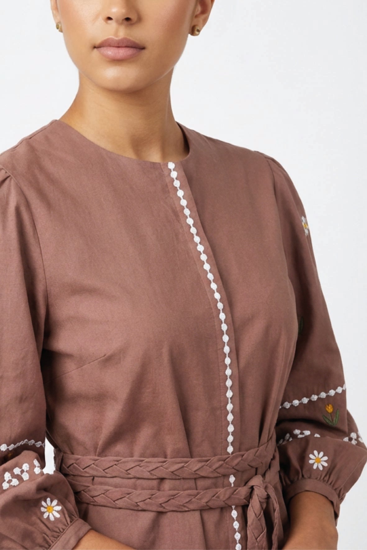 Fanm Mon Noen Dress detail featuring white daisy and golden floral embroidery, white embroidered trim and braided waist belt