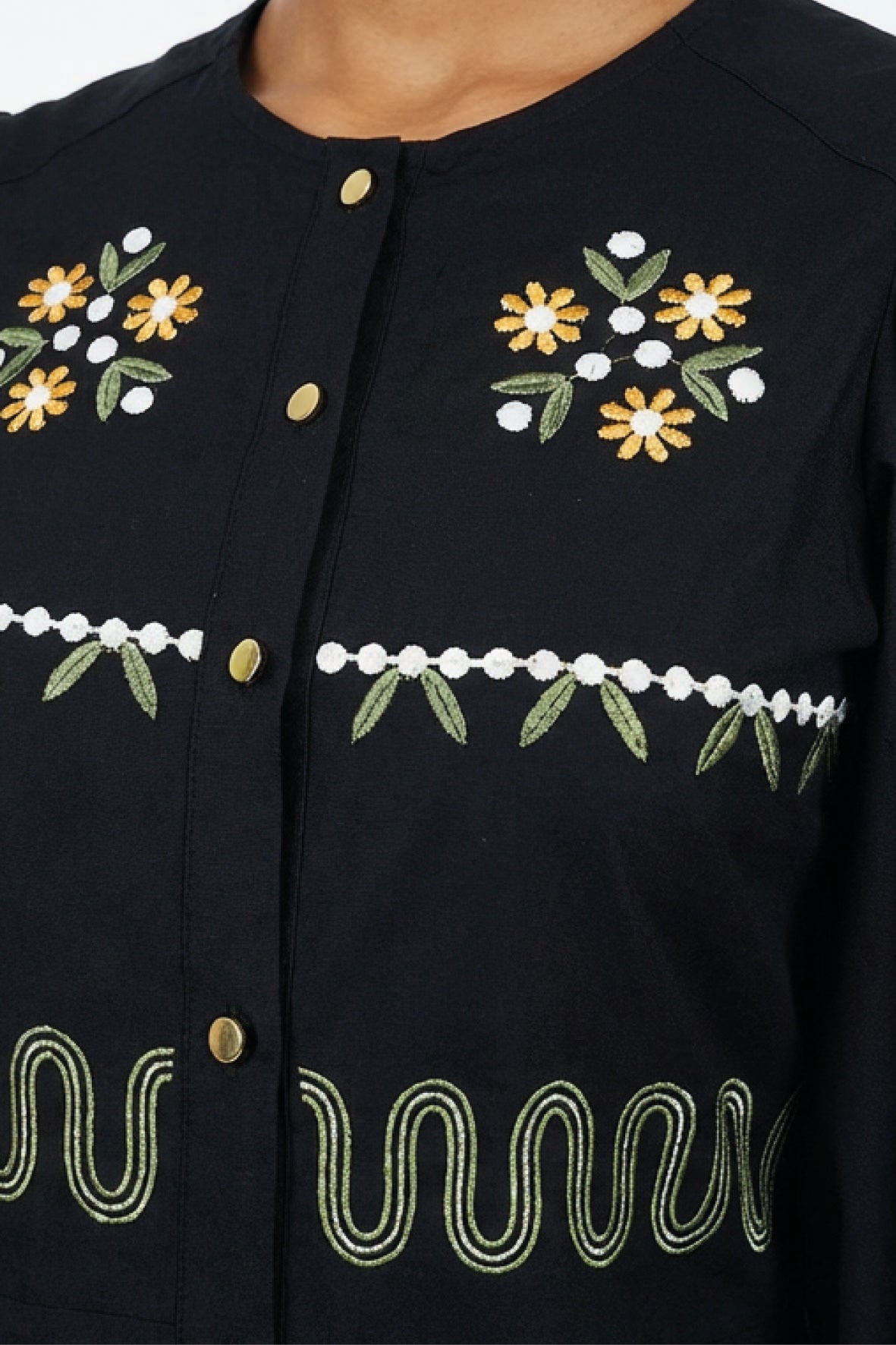 Close-up of the Fanm Mon Pomender Dress highlighting the hand-embroidered daisy blossoms, leafy vine motifs, decorative gold-tone buttons, and artisan embroidery across the bodice.