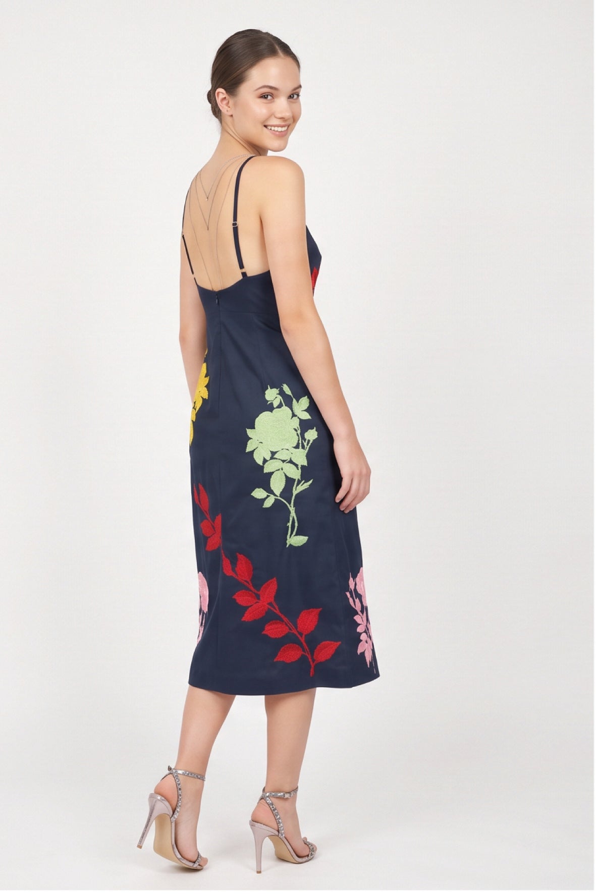 Back view of model wearing Fanm Mon Pout Dress with colorful floral embroidery and delicate open-back straps