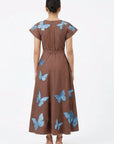 Fanm Mon Pulse Dress back view featuring blue butterfly embroidery, short flutter sleeves, a defined waist and full A-line midi skirt.