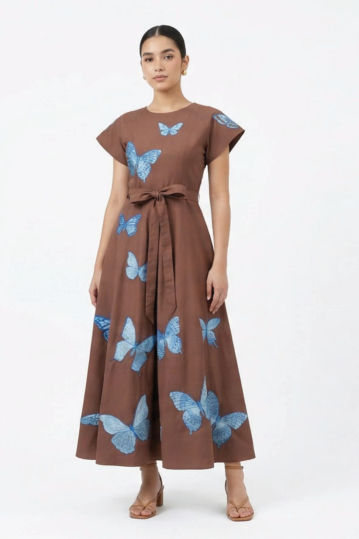 Fanm Mon Pulse Dress on model featuring scattered blue butterfly embroidery, short flutter sleeves, a self-tie waist and full midi skirt.