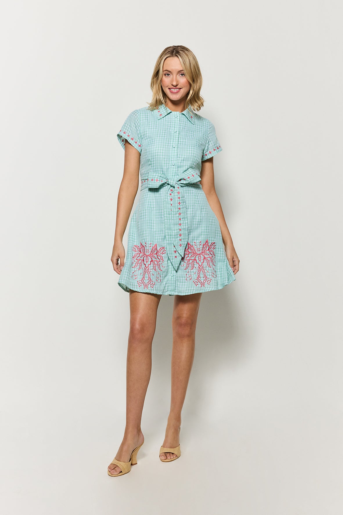 Model wearing Fanm Mon Ponto Shirt Dress in green plaid with floral embroidery details on a white background