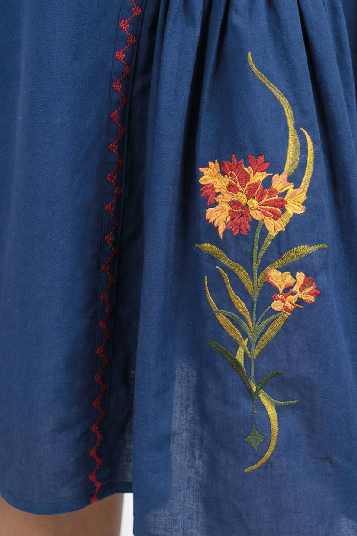 Close-up of the Fanm Mon Raya Dress highlighting intricate floral embroidery and contrast stitched detailing.