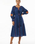 Model wearing the Fanm Mon Raya Dress featuring floral embroidered sleeves, tassel neckline, contrast stitching, and a self-tie waist belt.