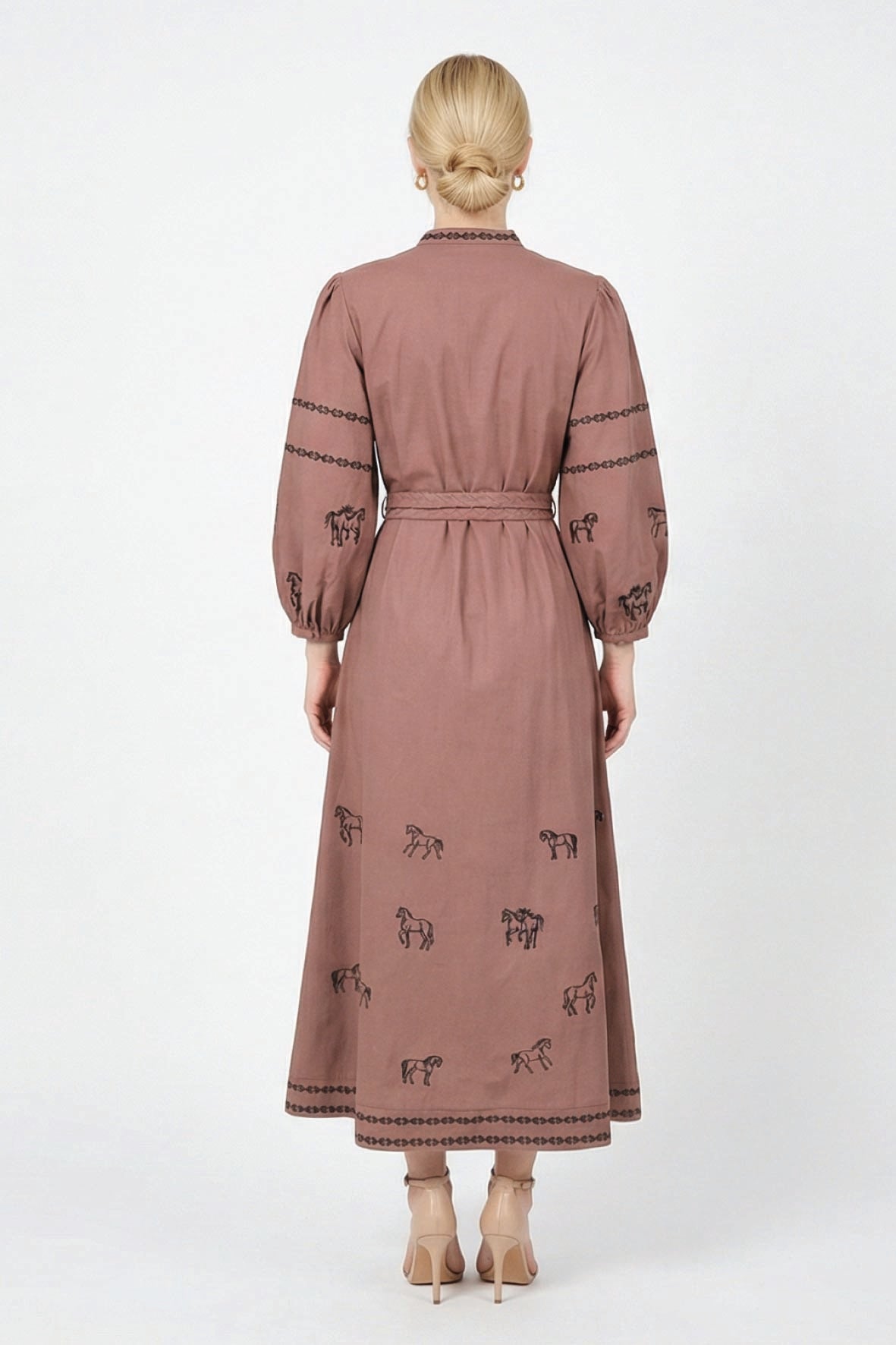 Back view of the Fanm Mon Sakura Dress featuring black horse embroidery, blouson sleeves, a braided waist belt, and double embroidered trim along the midi hem.