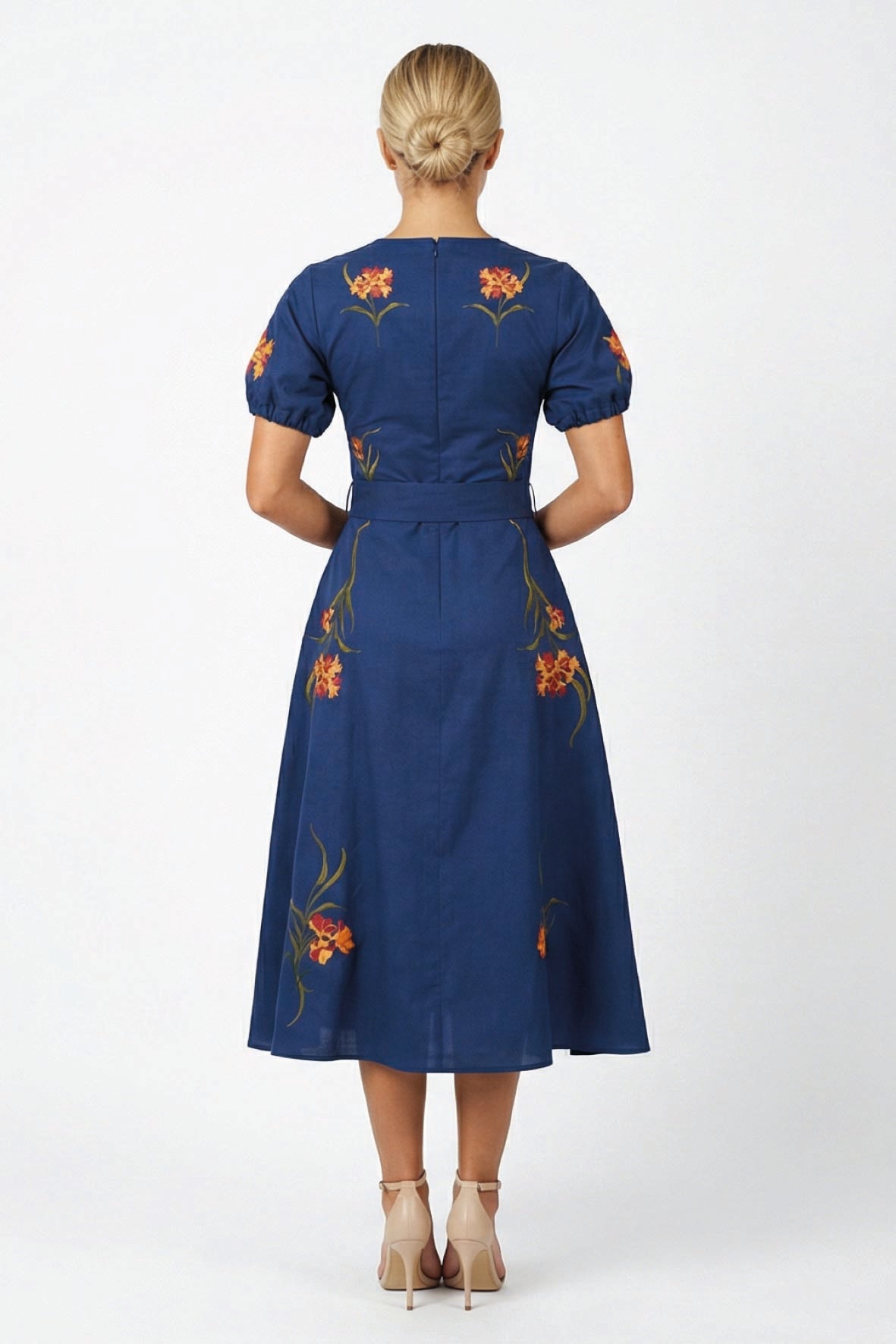 Back view of the Fanm Mon Simone Dress featuring floral embroidery, short puff sleeves, self-tie waist, and concealed back zip closure.