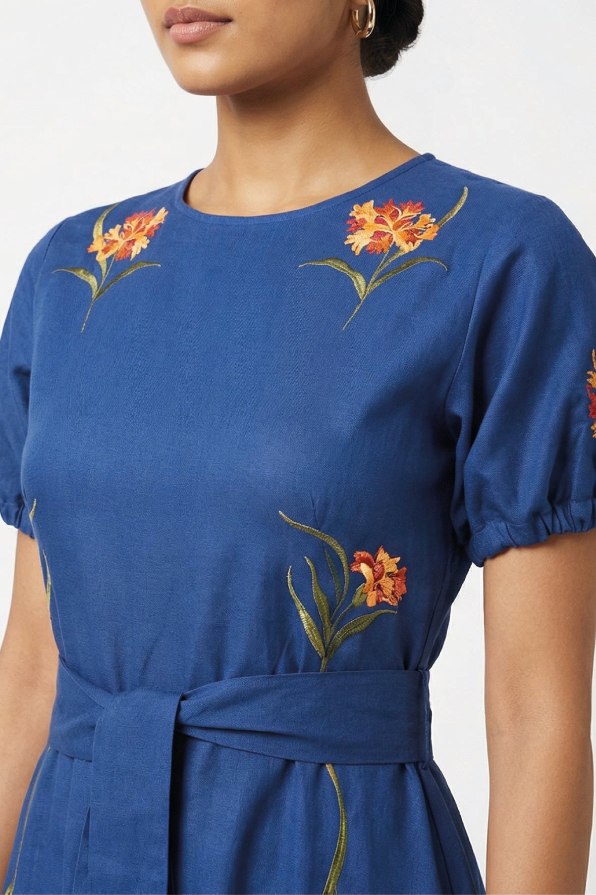 Close-up of the Fanm Mon Simone Dress highlighting intricate floral embroidery, round neckline, and self-tie waist.