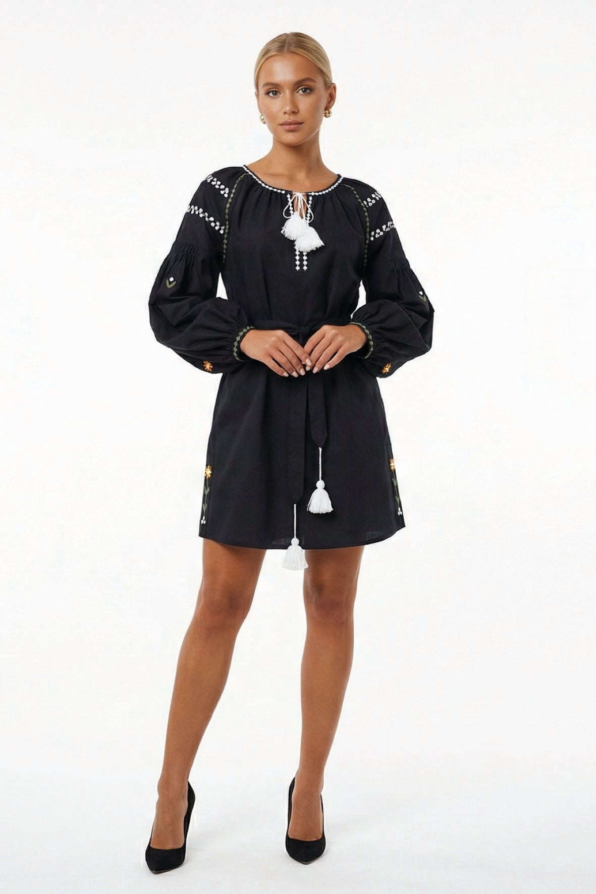 Model wearing the Fanm Mon Stella Dress featuring a gathered neckline, tassel ties, long balloon sleeves, floral embroidery, and a self-tie waist.