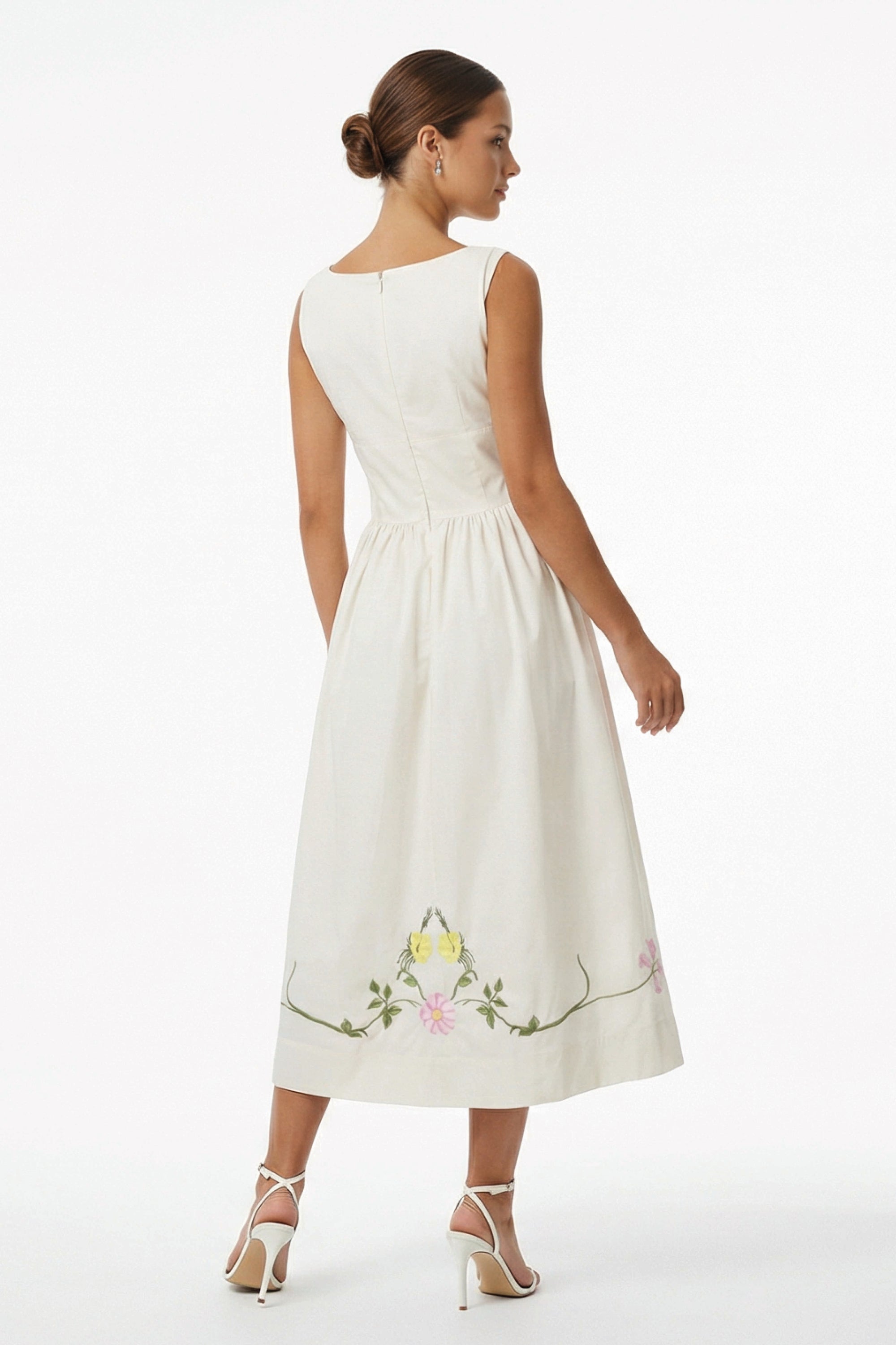 Back view of the Fanm Mon Veda Dress featuring a flowing A-line midi silhouette, gathered waist, concealed back zipper, and hand-embroidered floral vines along the hem.