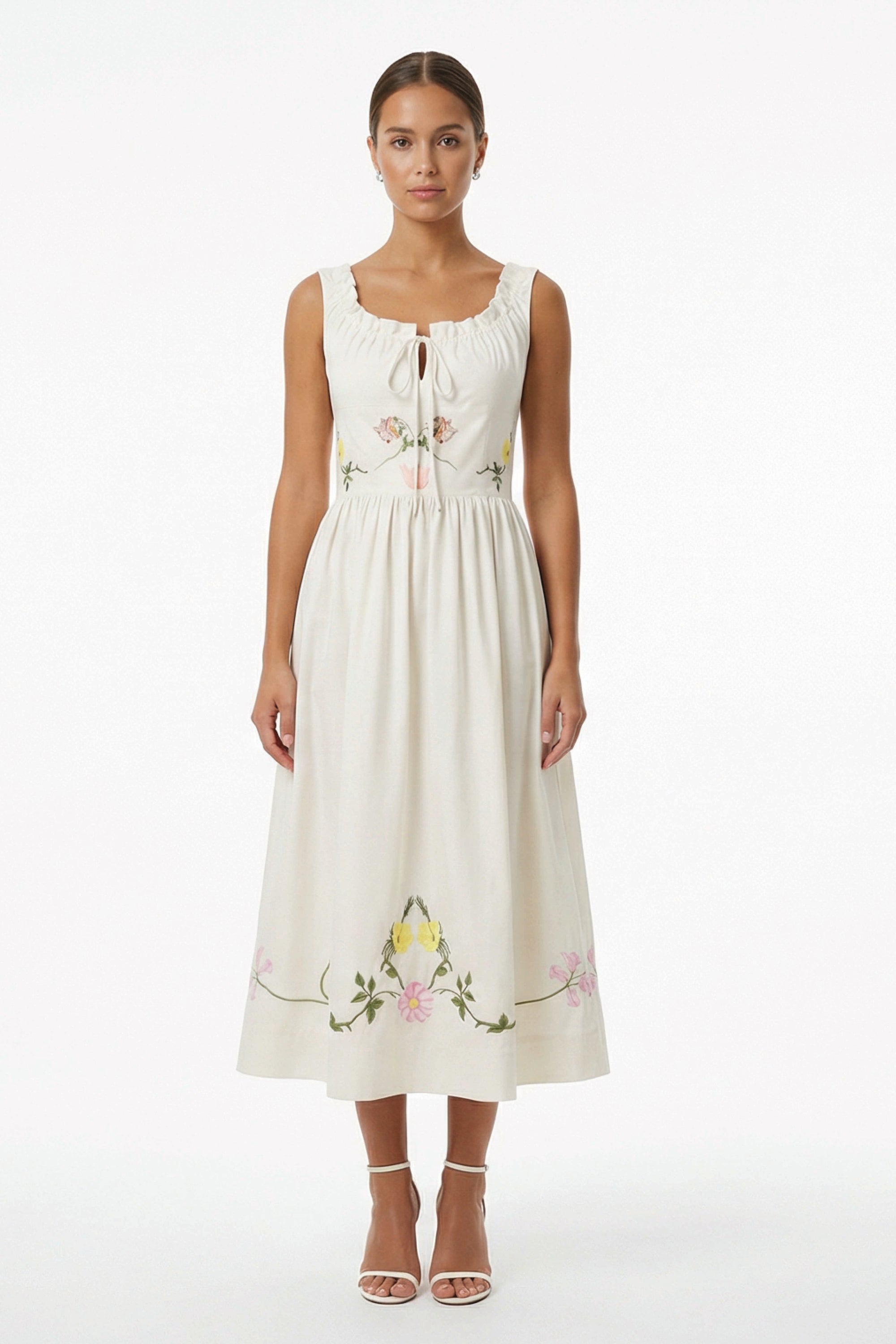 Model wearing the Fanm Mon Veda Dress featuring a softly gathered neckline with a self-tie detail, embroidered floral bodice, gathered waist, and flowing midi skirt.