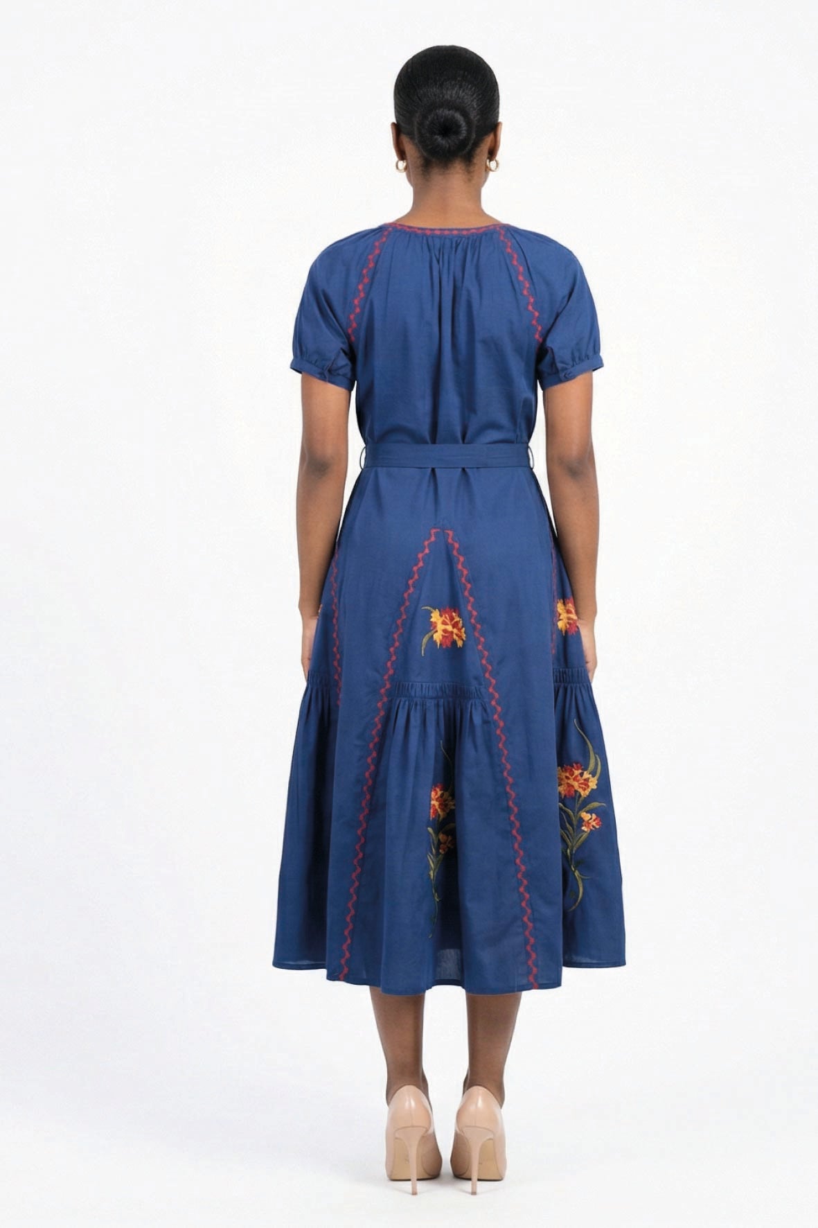 Back view of the Fanm Mon Venya Dress featuring contrast embroidery, a self-tie waist, and floral embroidered gathered skirt.