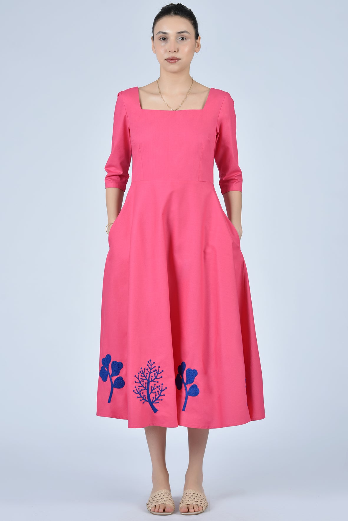 Fuchsia pink dress with blue coral-inspired embroidery on the hemline and square neckline. 