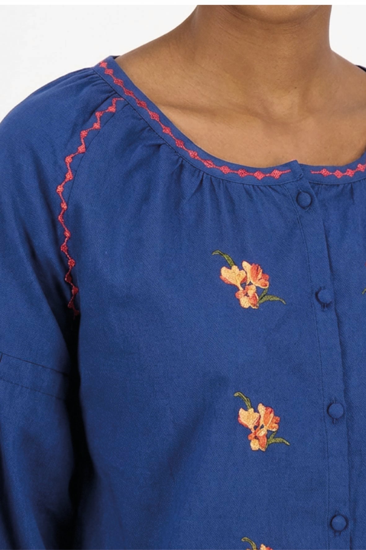 Detail of Fanm Mon Akik Top showing floral embroidery, contrast neckline trim and covered buttons