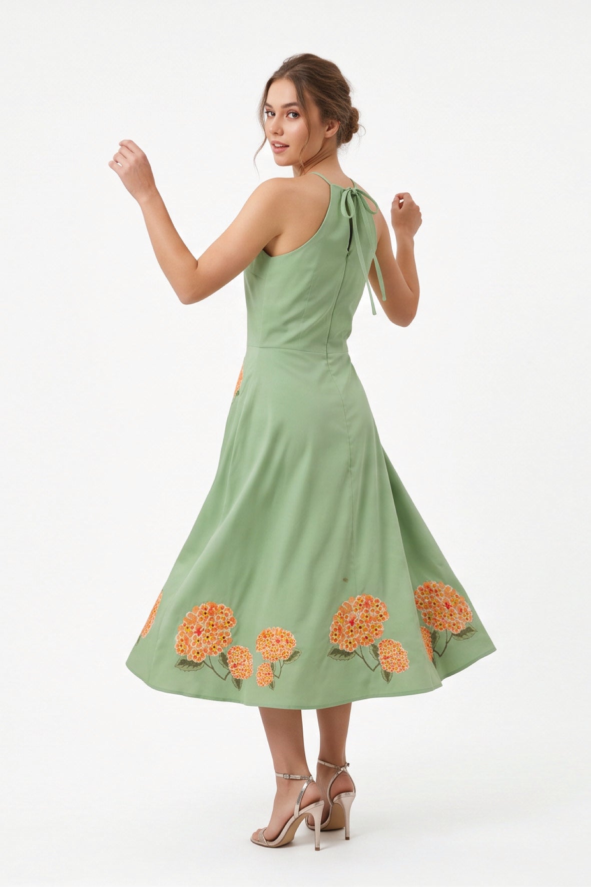 Back view of the Fanm Mon Fora Dress with a self-tie halterneck and hydrangea embroidery along the full midi skirt.