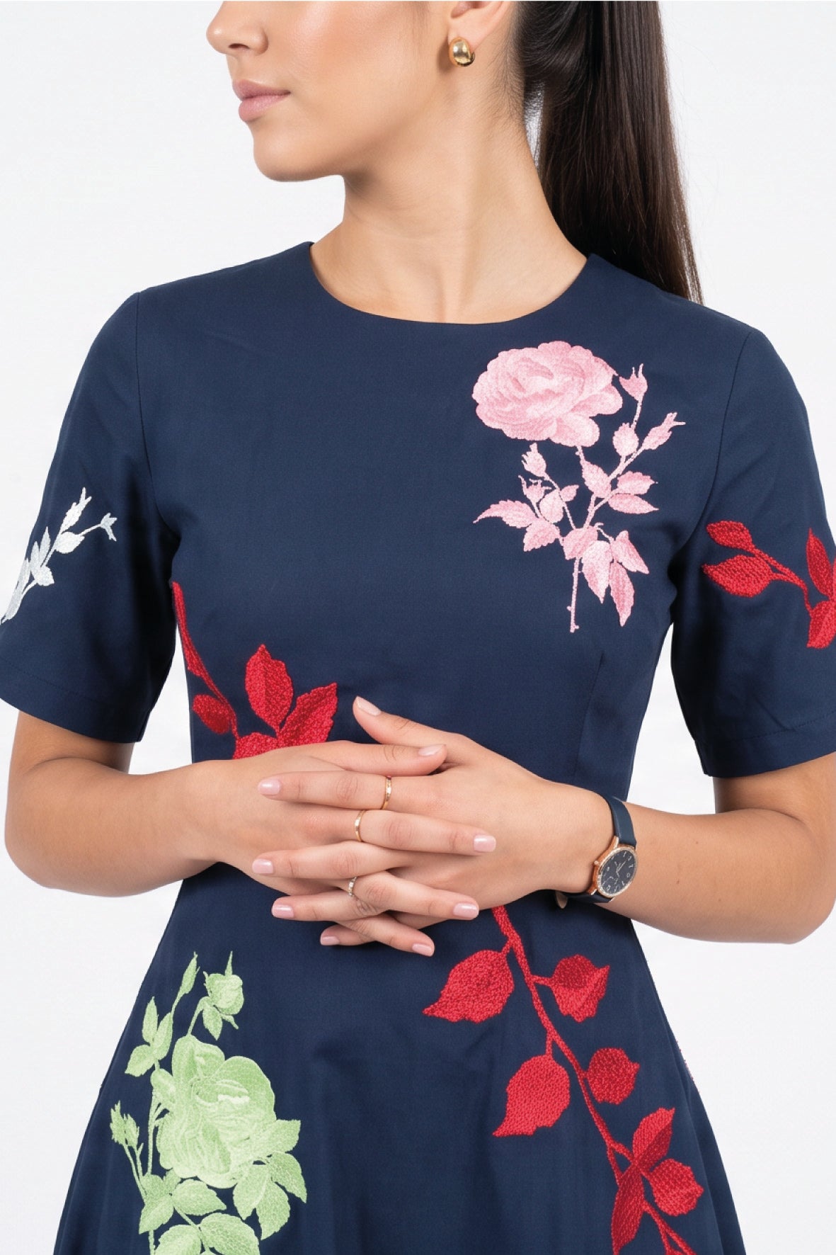 Close-up of Fanm Mon Gandi Dress in navy highlighting pink rose embroidery, contrasting red botanical motifs, and tailored short sleeves