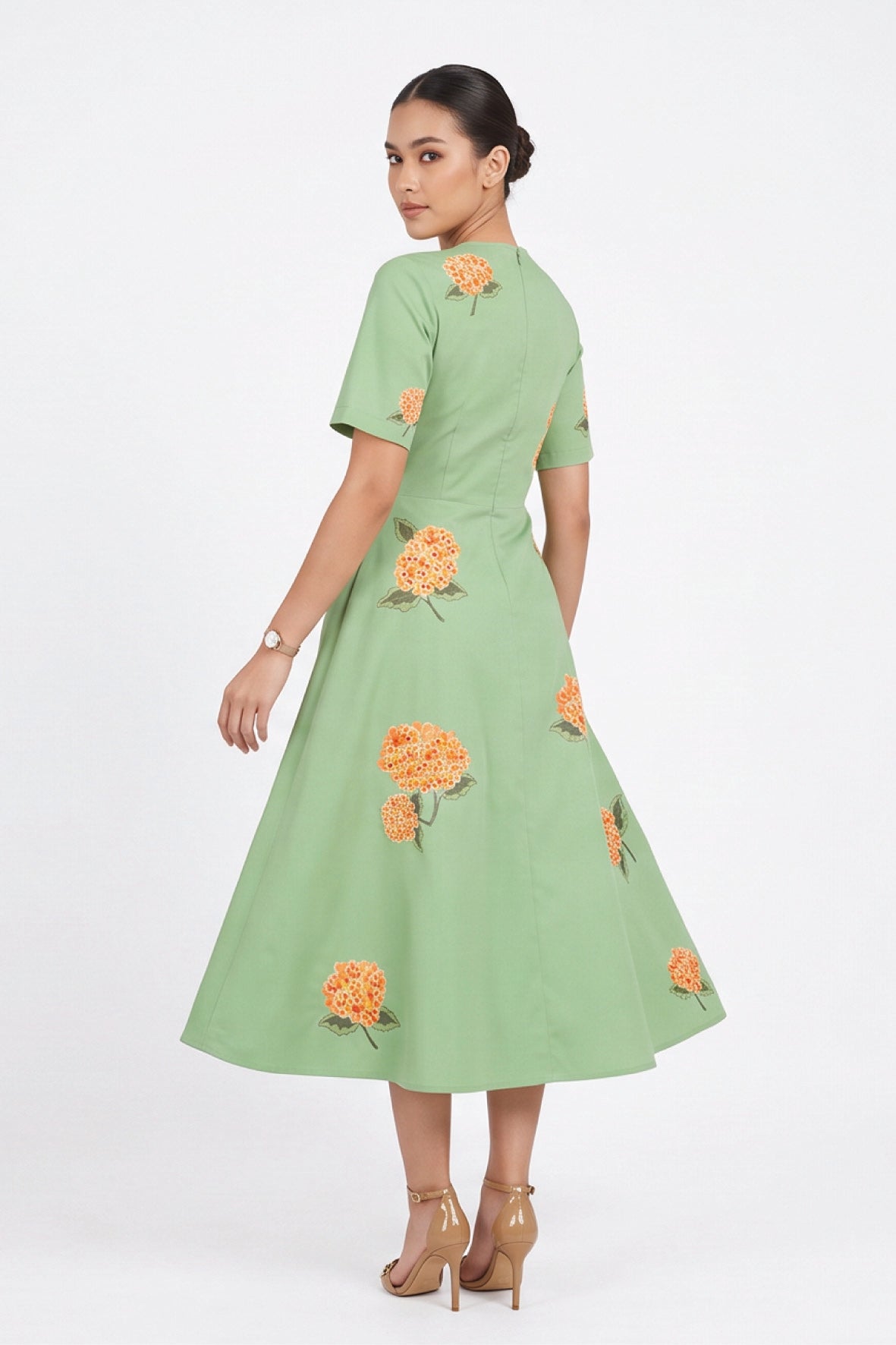 Back view of model wearing the Fanm Mon Gemlik Dress with scattered hydrangea embroidery and a full A-line midi silhouette.